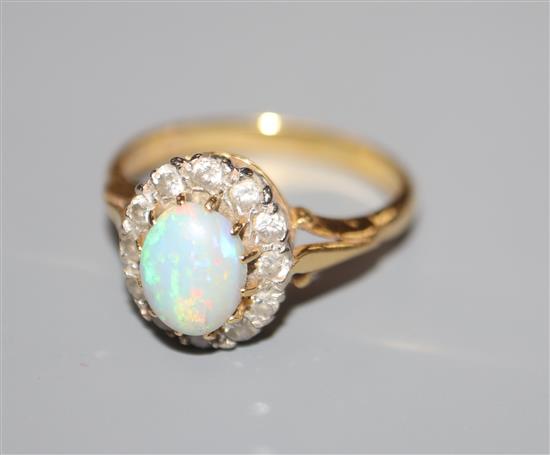 A modern 18ct gold, white opal and diamond oval cluster ring, size N.